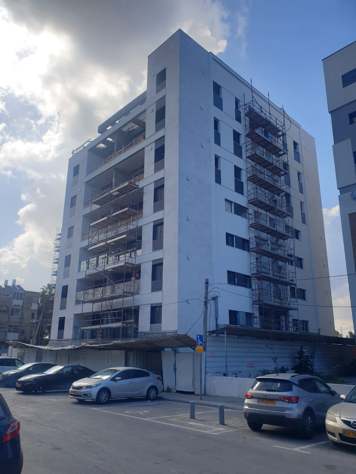 בניין מגורים בשלב עבודות חזית עם פיגומים